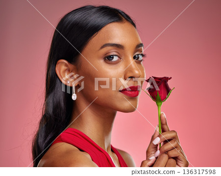 Beautiful, portrait and an Indian woman with a rose on a studio background for valentines day. Serious, model and face of a young girl with a flower for romance or love isolated on a backdrop Beautiful, portrait and an Indian woman with a rose on a studio background for valentines day. Serious, model and face of a young girl with a flower for romance or love isolated on a backdrop 136317598