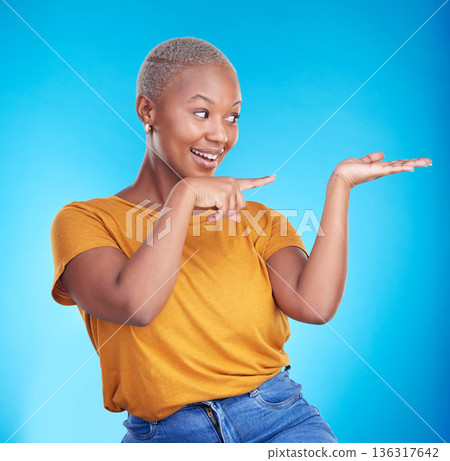 Decision, pointing and black woman with a smile, presentation and advertising on a blue studio background. Sales, female person or model with discount deal, sales and choice with promotion or showing Decision, pointing and black woman with a smile, presentation and advertising on a blue studio background. Sales, female person or model with discount deal, sales and choice with promotion or showing 136317642