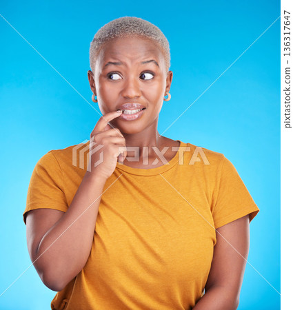 Black woman, biting nails and anxiety in studio with thinking, confused or ideas for decision by blue background. African girl, stress and finger in mouth for fear, scared or brainstorming for choice Black woman, biting nails and anxiety in studio with thinking, confused or ideas for decision by blue background. African girl, stress and finger in mouth for fear, scared or brainstorming for choice 136317647
