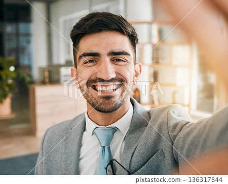 Face of businessman, selfie and smile in modern office with confidence, pride and happiness for startup entrepreneur. Digital photography, portrait and happy man in professional mindset in workplace. Face of businessman, selfie and smile in modern office with confidence, pride and happiness for startup entrepreneur. Digital photography, portrait and happy man in professional mindset in workplace. 136317844