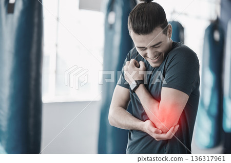 Hand, elbow pain and injury with the arm of a man in red highlight during a fitness workout. Healthcare, medical and emergency with a young male athlete holding a joint after an accident in the gym Hand, elbow pain and injury with the arm of a man in red highlight during a fitness workout. Healthcare, medical and emergency with a young male athlete holding a joint after an accident in the gym 136317961