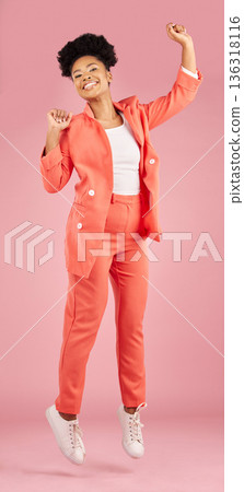 Portrait, fashion and jumping with an afro woman in studio isolated on pink background for trendy style. Smile, excited and celebration with a happy young african person winning in a clothes outfit Portrait, fashion and jumping with an afro woman in studio isolated on pink background for trendy style. Smile, excited and celebration with a happy young african person winning in a clothes outfit 136318116