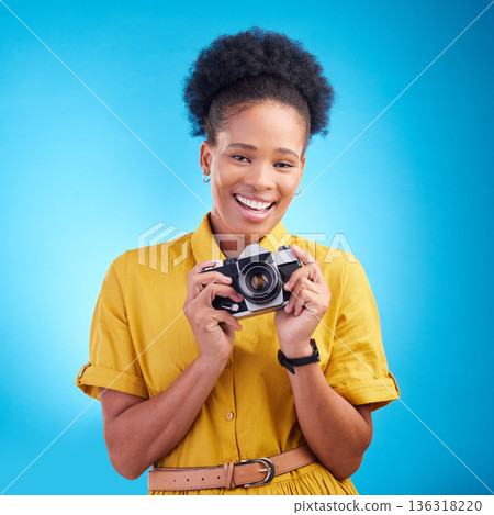 Photography, portrait and black woman with camera, smile and isolated on blue background, creative artist job and talent. Art, face of happy photographer with hobby or career in studio for photoshoot 136318220