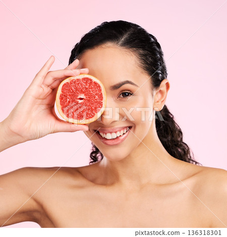Beauty, grapefruit and face of a happy woman with skin care, dermatology and natural glow. Portrait of a young female aesthetic model with fruit for vitamin c, cosmetics or healthy diet for wellness 136318301