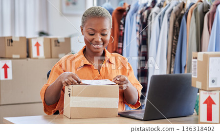 Black woman, fashion designer and label box in small business for courier service or delivery at boutique. Happy African female person packing parcel for order, payment or purchase in clothing store 136318402