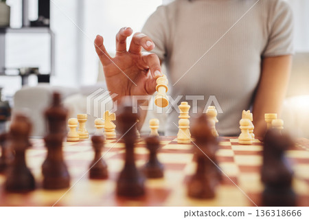 Chess, game and woman with board moving piece for strategy, thinking and challenge in home. Competition, problem solving and hands of female person with chessboard in living room playing to checkmate 136318666