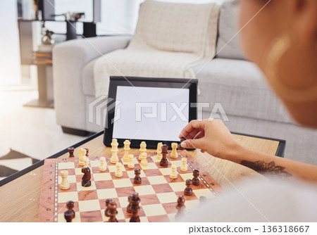 Video call, chess and woman with tablet, mockup and screen in gaming connection in living room. Thinking, internet and chessboard, virtual strategy board game and African girl problem solving in home Video call, chess and woman with tablet, mockup and screen in gaming connection in living room. Thinking, internet and chessboard, virtual strategy board game and African girl problem solving in home 136318667