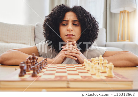 Thinking, strategy and face of woman with chess for problem solving, planning and challenge at home. Competition, contest and female person with chessboard in living room ready for playing games Thinking, strategy and face of woman with chess for problem solving, planning and challenge at home. Competition, contest and female person with chessboard in living room ready for playing games 136318668