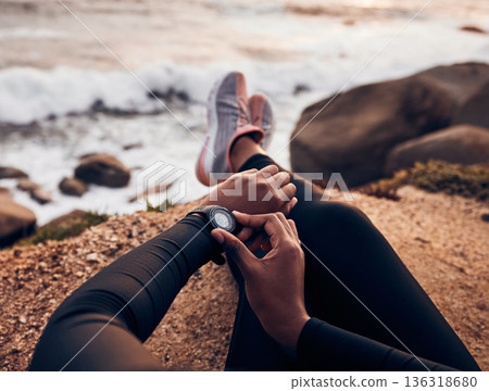 Relax, check and smart watch with hand of woman on rock for running, fitness tracker and heart rate. Workout, exercise and goal with closeup of female runner at beach for monitor, goals and time Relax, check and smart watch with hand of woman on rock for running, fitness tracker and heart rate. Workout, exercise and goal with closeup of female runner at beach for monitor, goals and time 136318680