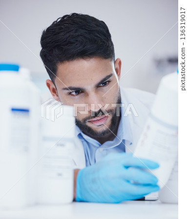 Laboratory, man or scientist reading bottle to check medical stock or info on cure breakthrough. Research study, container label or science researcher in manufacturing job with chemical inventory Laboratory, man or scientist reading bottle to check medical stock or info on cure breakthrough. Research study, container label or science researcher in manufacturing job with chemical inventory 136319017