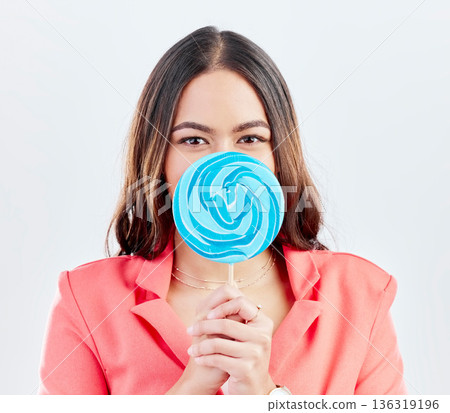 Portrait, lollipop and woman with sweets, sugar and confident girl on a white studio background. Face, female person or model with candy, dessert and cover with treats, cheerful and confectionary 136319196