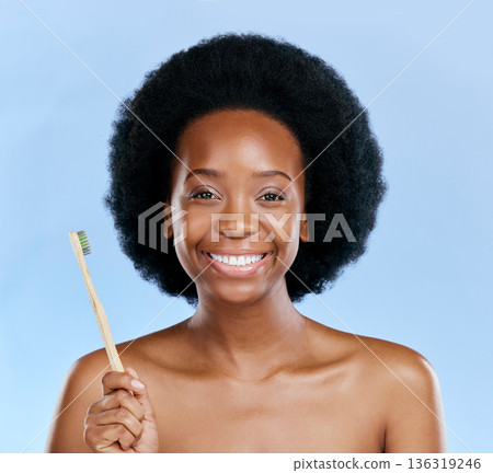 Face, bamboo toothbrush and black woman smile in studio isolated on a blue background. Portrait, brushing teeth and model with natural, eco friendly or healthy wood for dental, cleaning or hygiene. Face, bamboo toothbrush and black woman smile in studio isolated on a blue background. Portrait, brushing teeth and model with natural, eco friendly or healthy wood for dental, cleaning or hygiene. 136319246