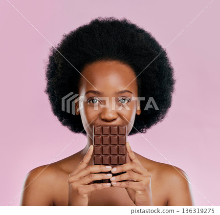 Portrait, chocolate and black woman with snack, natural beauty and sugar treat on a studio background. Face, female person or Jamaican model with sweets, cocoa candy and delicious snack with calories 136319275