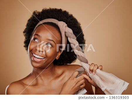 Happy, afro or black woman with headband thinking of change or beauty in studio on brown background. Tie, smile or thoughtful African girl model excited by haircare idea, scarf hairstyle or self love 136319303