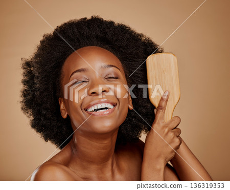 Happy black woman, brush and hair care in studio, brown background and treatment of curly texture. Natural beauty, smile and face of young african female model comb clean, healthy or afro hairstyle Happy black woman, brush and hair care in studio, brown background and treatment of curly texture. Natural beauty, smile and face of young african female model comb clean, healthy or afro hairstyle 136319353