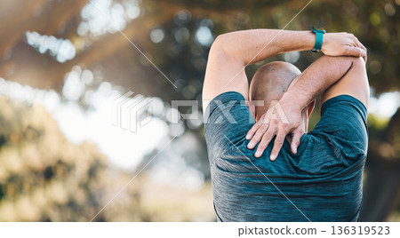 Stretching, outdoor and man in a park with sport warm up and muscle strain from fitness and workout. Exercise problem, male person and back with medical, health massage and physio for training 136319523