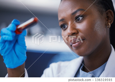 Science, blood vial and female scientist in a lab working on a medical experiment, test or exam. Biotechnology, pharmaceutical and African woman researcher doing scientific research in a laboratory. 136319593