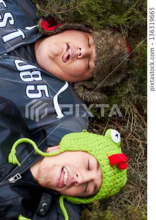 Hangover, drunk and men sleeping on grass with tongue out in top view after party. Outdoor, alcoholism and tired friends on ground together with plus size person resting in a park in the morning. 136319665