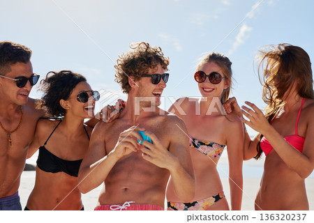 Social media, travel and friends on the beach with a phone to post a status update while on vacation together. Mobile, freedom and a group of young people outdoor in nature for summer holiday Social media, travel and friends on the beach with a phone to post a status update while on vacation together. Mobile, freedom and a group of young people outdoor in nature for summer holiday 136320237