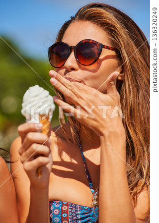 Ice cream, woman and lick finger outdoor on summer vacation alone. Gelato, food and person in bikini with dessert, eating vanilla sweets and enjoying delicious snack on holiday, freedom and travel. 136320249