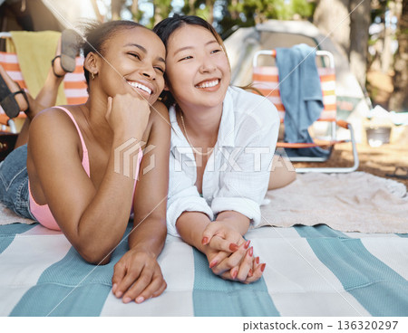 Happy, relax and girl friends on a picnic while on camp weekend trip in the woods or nature. Happiness, smile and young interracial female people resting on blanket in outdoor park, garden or forest. Happy, relax and girl friends on a picnic while on camp weekend trip in the woods or nature. Happiness, smile and young interracial female people resting on blanket in outdoor park, garden or forest. 136320297