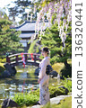身著和服的日本女子在櫻花盛開的日式庭園中享受寧靜。 136320441