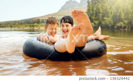 Lake, swimming and mother with child in water while camping in a forest for vacation or holiday together. Travel, inflatable ring and parent bonding with kid in nature for freedom, love and happiness 136320442