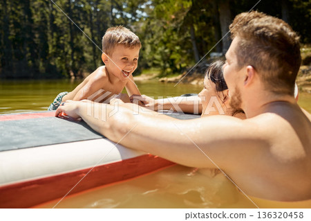 Happy, family with boat and in lake together with smile for bonding time. Summer vacation or holiday break, happiness or freedom and people in a river with outdoor activity for adventure or wellness Happy, family with boat and in lake together with smile for bonding time. Summer vacation or holiday break, happiness or freedom and people in a river with outdoor activity for adventure or wellness 136320458