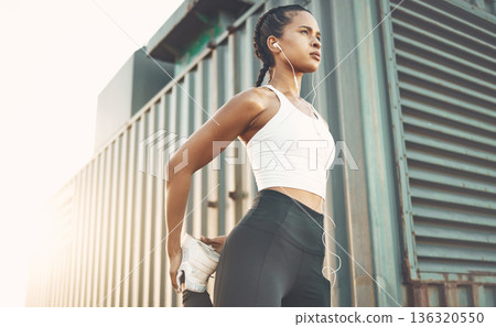 Fitness, sports and woman stretching legs in city or shipping dock listening to music, audio and track. Sports, healthy body and female person outdoors for exercise, training and warm up for running 136320550
