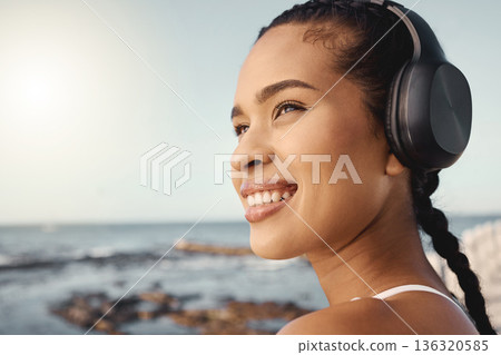 Headphones, fitness and happy woman at beach for exercise, vision or running mindset, goals or music ideas. Health, podcast and athlete, runner or sports person thinking and listening to audio by sea Headphones, fitness and happy woman at beach for exercise, vision or running mindset, goals or music ideas. Health, podcast and athlete, runner or sports person thinking and listening to audio by sea 136320585