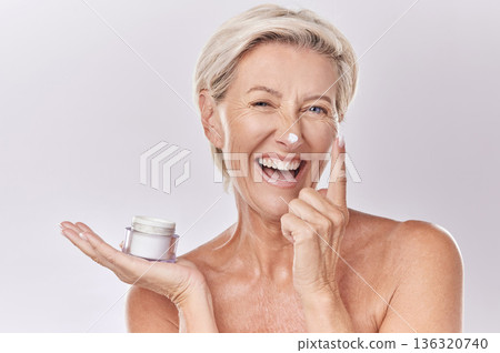 Portrait, cream and beauty with senior woman, happy with skincare and dermatology on white background. Sunscreen, moisturizer and face care, female model apply lotion with glass container and skin Portrait, cream and beauty with senior woman, happy with skincare and dermatology on white background. Sunscreen, moisturizer and face care, female model apply lotion with glass container and skin 136320740