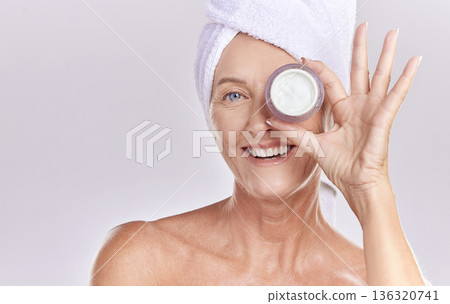 Portrait, mature or happy woman with face cream, towel or beauty in studio isolated on white background. Dermatology creme, smile or senior lady with clean facial skincare cosmetics or glowing shine Portrait, mature or happy woman with face cream, towel or beauty in studio isolated on white background. Dermatology creme, smile or senior lady with clean facial skincare cosmetics or glowing shine 136320741