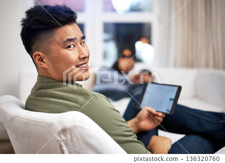 Man, tablet and remote work on sofa in family home with review, charts or screen in living room. Asian person, graphs and click with tech, app and insight with project management in lounge at house Man, tablet and remote work on sofa in family home with review, charts or screen in living room. Asian person, graphs and click with tech, app and insight with project management in lounge at house 136320760