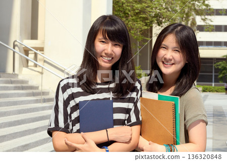 University, portrait of asian friends on campus and with books happy for learning development. Education or knowledge, positivity or academy and students together at college building outdoor 136320848