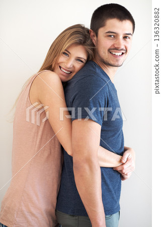 Portrait, hug and couple in studio happy, bonding and having fun against a wall background. Face, smile and woman embracing man with care, romance and love while enjoying their relationship together 136320882