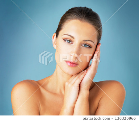 Skincare, cosmetics and serious portrait of woman with salon dermatology, makeup and blue background. Shine, skin care and wellness, face of model with beauty and spa facial glow on studio backdrop. 136320966