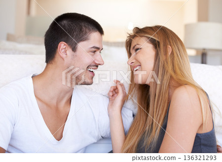 Talk, laugh and happy couple bond on a sofa with conversation, day off and chilling in their home. Love, speaking and woman with man on couch smile, discussion and enjoy relationship in a living room 136321293