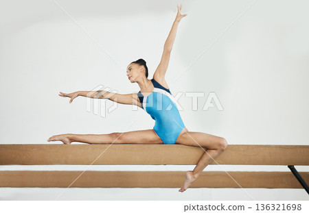 Gymnastics, sports and woman on beam in gym for rhythmic body movement, training and exercise. Aerobics performance, health and female dancer for competition, workout and creative dance practice Gymnastics, sports and woman on beam in gym for rhythmic body movement, training and exercise. Aerobics performance, health and female dancer for competition, workout and creative dance practice 136321698