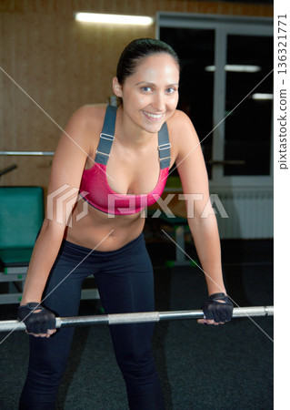 Portrait, smile and woman at barbell in gym for exercise, training and power of strong bodybuilding. Happy female athlete, fitness workout and weights for healthy muscles, sports and strength in club Portrait, smile and woman at barbell in gym for exercise, training and power of strong bodybuilding. Happy female athlete, fitness workout and weights for healthy muscles, sports and strength in club 136321771