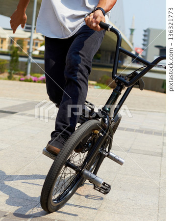 Bicycle, wheel trick and man on street for sports, balance and action at urban skatepark. Closeup of person, bike stunt and cycling challenge in city for skill, fun performance and freedom outdoors 136321773
