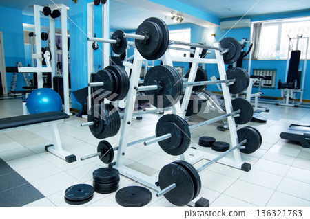 Barbell rack, gym interior and fitness with equipment for wellness, healthy bodybuilding or training. Exercise, workout or health club with metal weights on shelf, strong body development and sports Barbell rack, gym interior and fitness with equipment for wellness, healthy bodybuilding or training. Exercise, workout or health club with metal weights on shelf, strong body development and sports 136321783