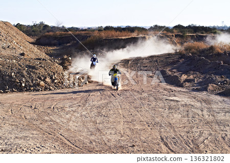 People in race, motorcycle and sport with speed, action and energy on off road track, transportation and outdoor. Competition, dirt bike and performance with fast biker, exercise and challenge 136321802