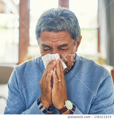 Senior man, sick and nose blowing in home from virus, allergy and illness with fever Tired, tissue and elderly male person in a house lounge with sneeze from covid and flu with hayfever allergies 136321814