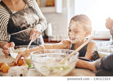 Learning, playing or messy kid baking in kitchen with a young girl smiling with flour on a dirty face at home. Smile, happy or parent cooking or teaching a fun daughter to bake for child development 136321924