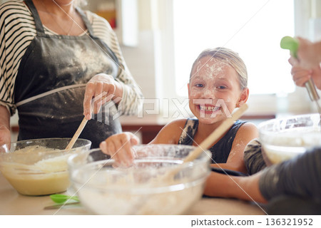Portrait, playing or messy girl baking in kitchen with a young kid smiling with flour on a dirty face at home. Smile, happy or parent cooking or teaching a fun daughter to bake for child development 136321952