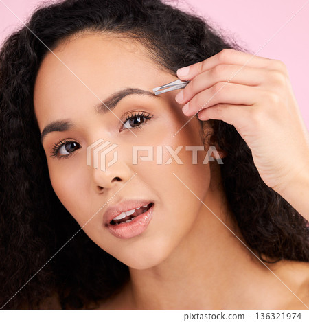 Face, beauty and woman with tweezer for eyebrow in studio isolated on pink background. Natural portrait, facial plucking or hair removal of serious model for self care, wellness or grooming aesthetic Face, beauty and woman with tweezer for eyebrow in studio isolated on pink background. Natural portrait, facial plucking or hair removal of serious model for self care, wellness or grooming aesthetic 136321974