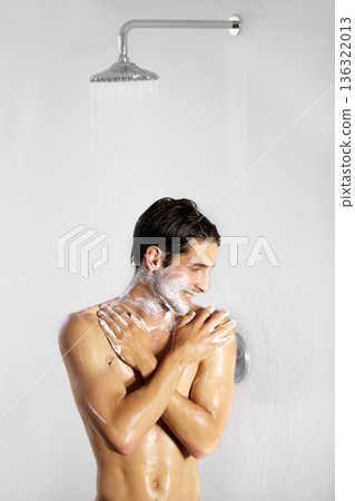 Shower, man and home with body cleaning and soap in the morning in bathroom. Water, young male person and smile with hygiene and clean skin care in a house with cosmetic grooming and shaving foam Shower, man and home with body cleaning and soap in the morning in bathroom. Water, young male person and smile with hygiene and clean skin care in a house with cosmetic grooming and shaving foam 136322013