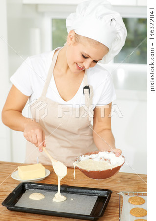 Happy woman, bakery or chef baking cookies with dough or pastry in a kitchen and is happy decorating his recipe. Food business, dessert or girl baker working in preparation of a sweet meal or biscuit 136322041