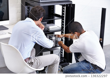 Server room, man and technician working with electronics for hardware maintenance of glitch in office. IT support, worker and electrical engineer fixing internet connection for information technology 136322297