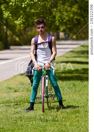 Fashion, street wear and man with a bicycle in a city for eco friendly or sustainable transport on urban background. Style, attitude and male person posing with a bike for cycling, commute or travel Fashion, street wear and man with a bicycle in a city for eco friendly or sustainable transport on urban background. Style, attitude and male person posing with a bike for cycling, commute or travel 136322306